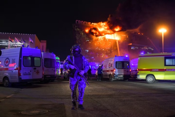 A Russian Rosguardia (National Guard) servicemen secures an area as a massive blaze seen over the Crocus City Hall. Photo / AP