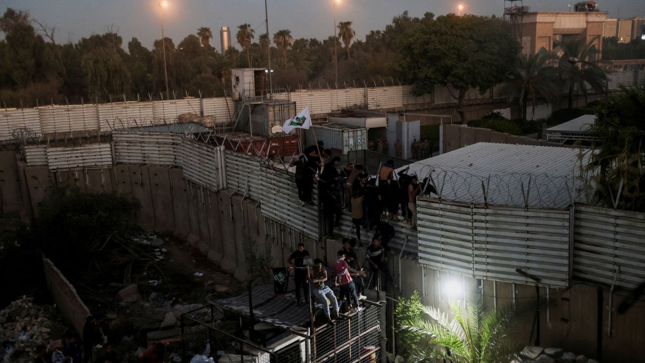 Protesters climb a fence near the Swedish embassy in Baghdad on July 20, 2023. Ahmed Saad/Reuters