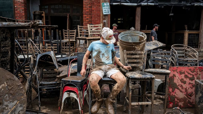 Porter Edwards, 10, helps his father clean up debris at Mad Co Brew House in the aftermath of Helene in Marshall, North Carolina. Photo / Jabin Botsford, The Washington Post