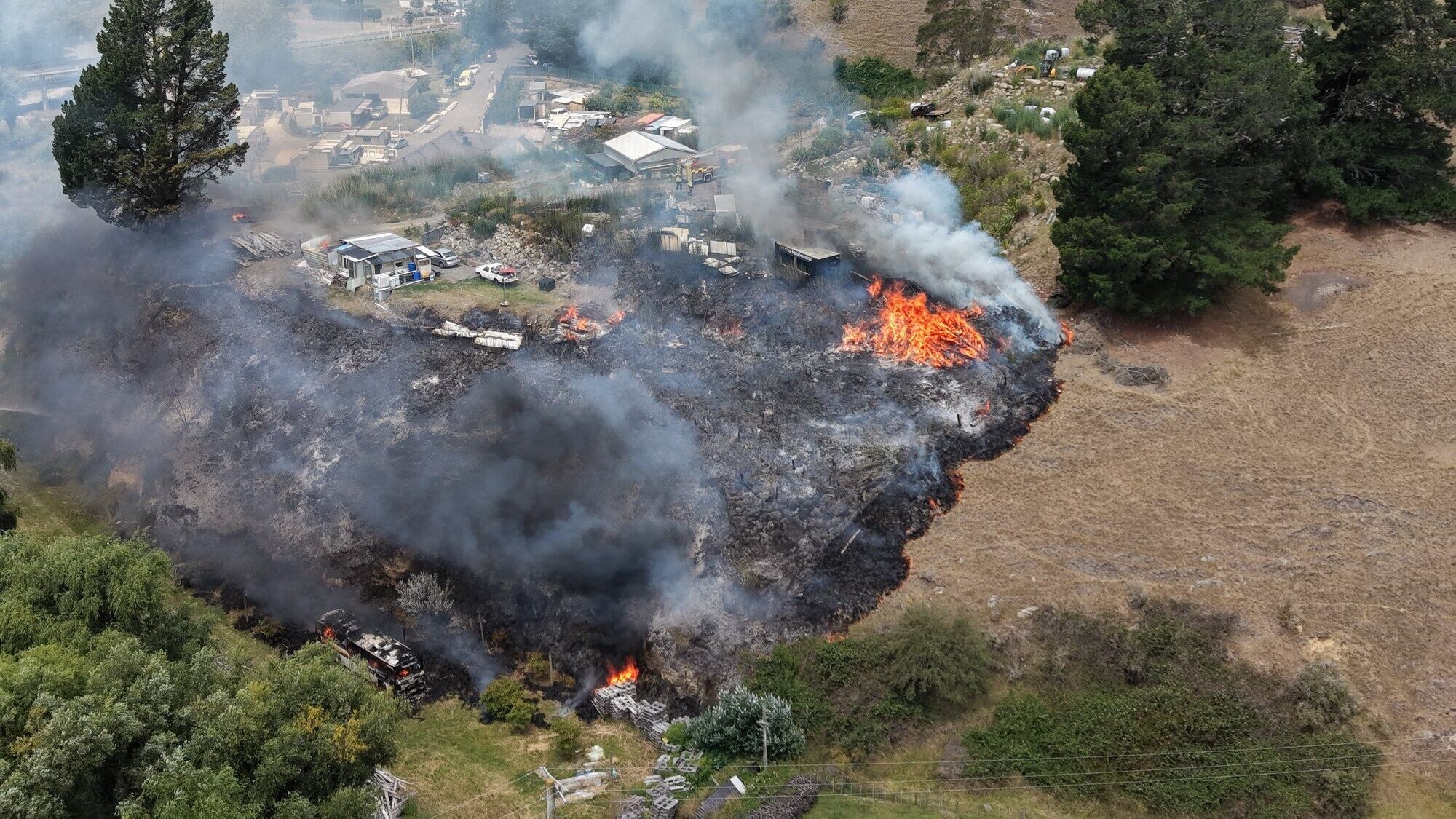 House hit by hillside wildfire as firefighters fight to control blaze