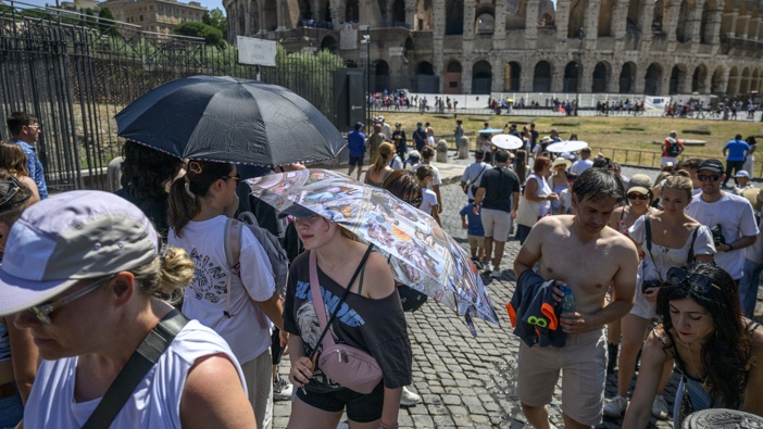 People hold umbrellas to protect themselves from the sun during an ongoing heat wave with temperatures reaching 40 degrees, at Colosseo area, on July 1, 2025 in Rome, Italy. (Photo by Antonio Masiello/Getty Images)