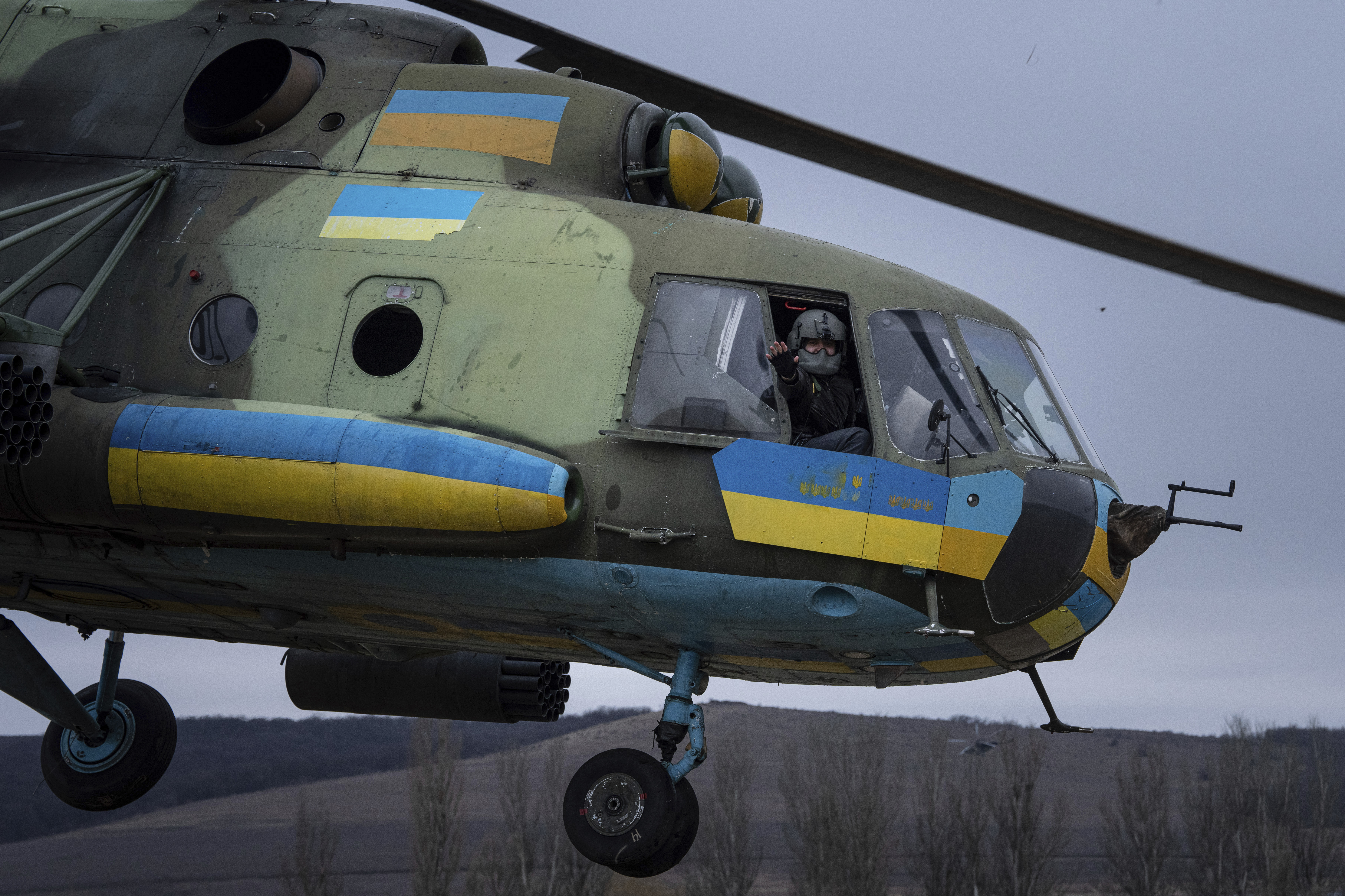 A Ukrainian pilot waves to his comrades from an Mi-8 combat helicopter during a combat mission in Donetsk region, Ukraine. Photo / AP