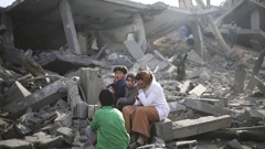 Palestinians sit by the destruction from the Israeli bombardment of the Gaza Strip in Rafah. Photo / AP