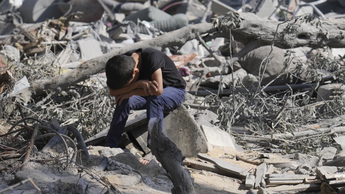 A Palestinian boy sits on the rubble of the building destroyed in an Israeli airstrike in Bureij refugee camp Gaza Strip, Wednesday, Oct. 18, 2023. Photo / AP