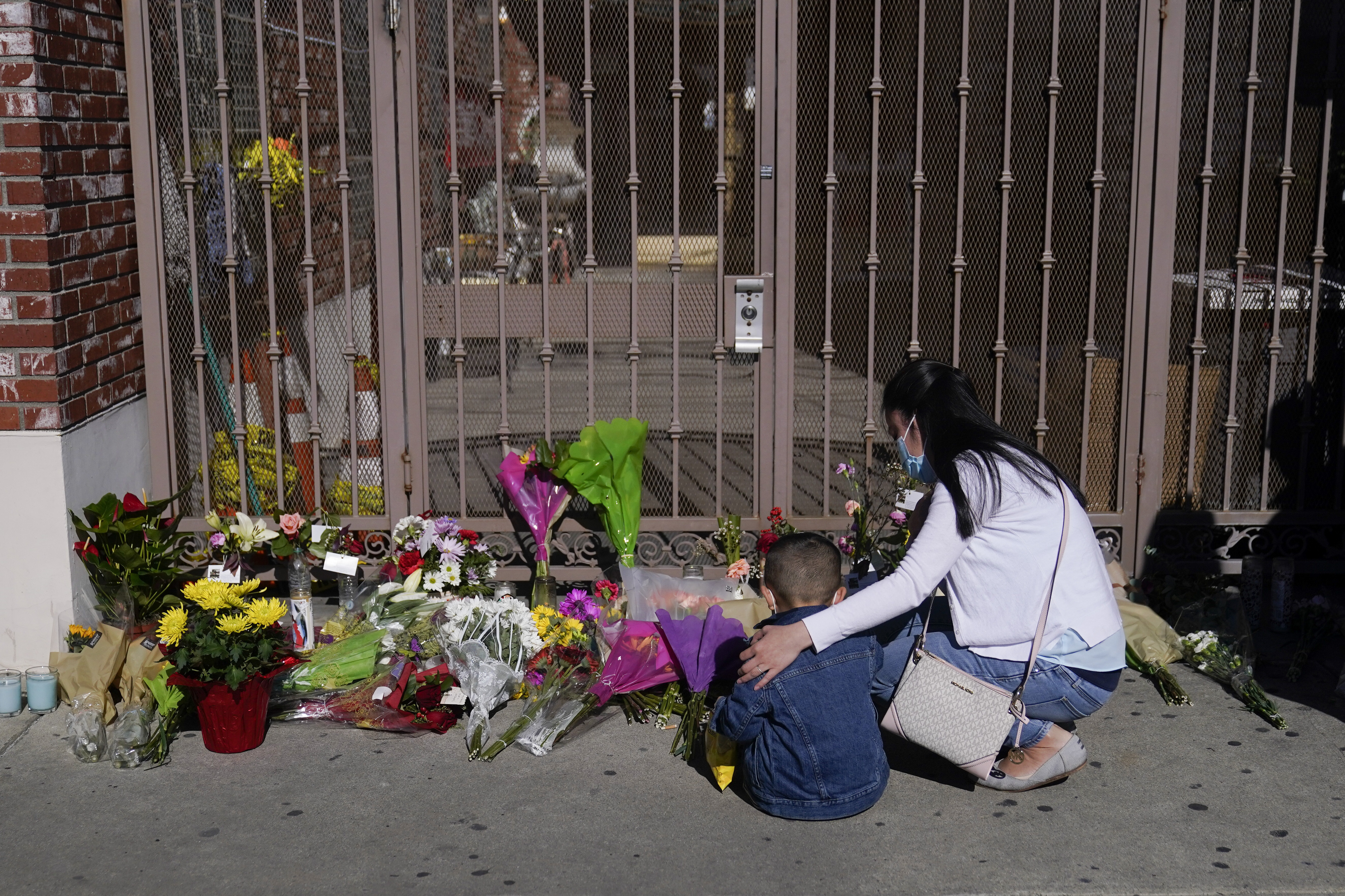 A woman comforts her son while visiting a makeshift memorial outside Star Ballroom Dance Studio in Monterey Park, Calif., Monday, Jan. 23, 2023. Photo / AP
