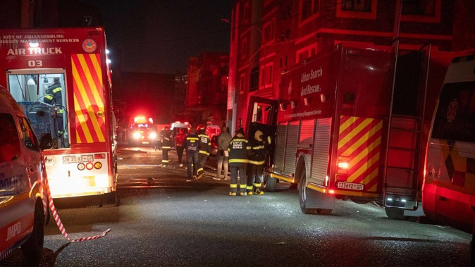 Fire fighters work on the scene of a deadly blaze in downtown Johannesburg. Photo / AP
