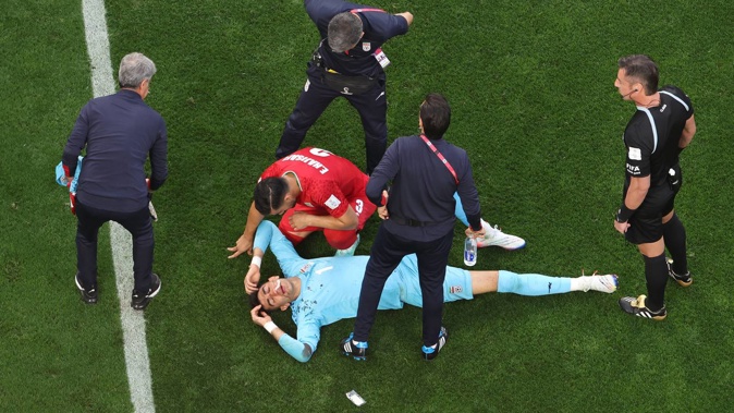 Alireza Beiranvand of Iran is attended to by medical staff after sustaining an injury. Photo / Getty