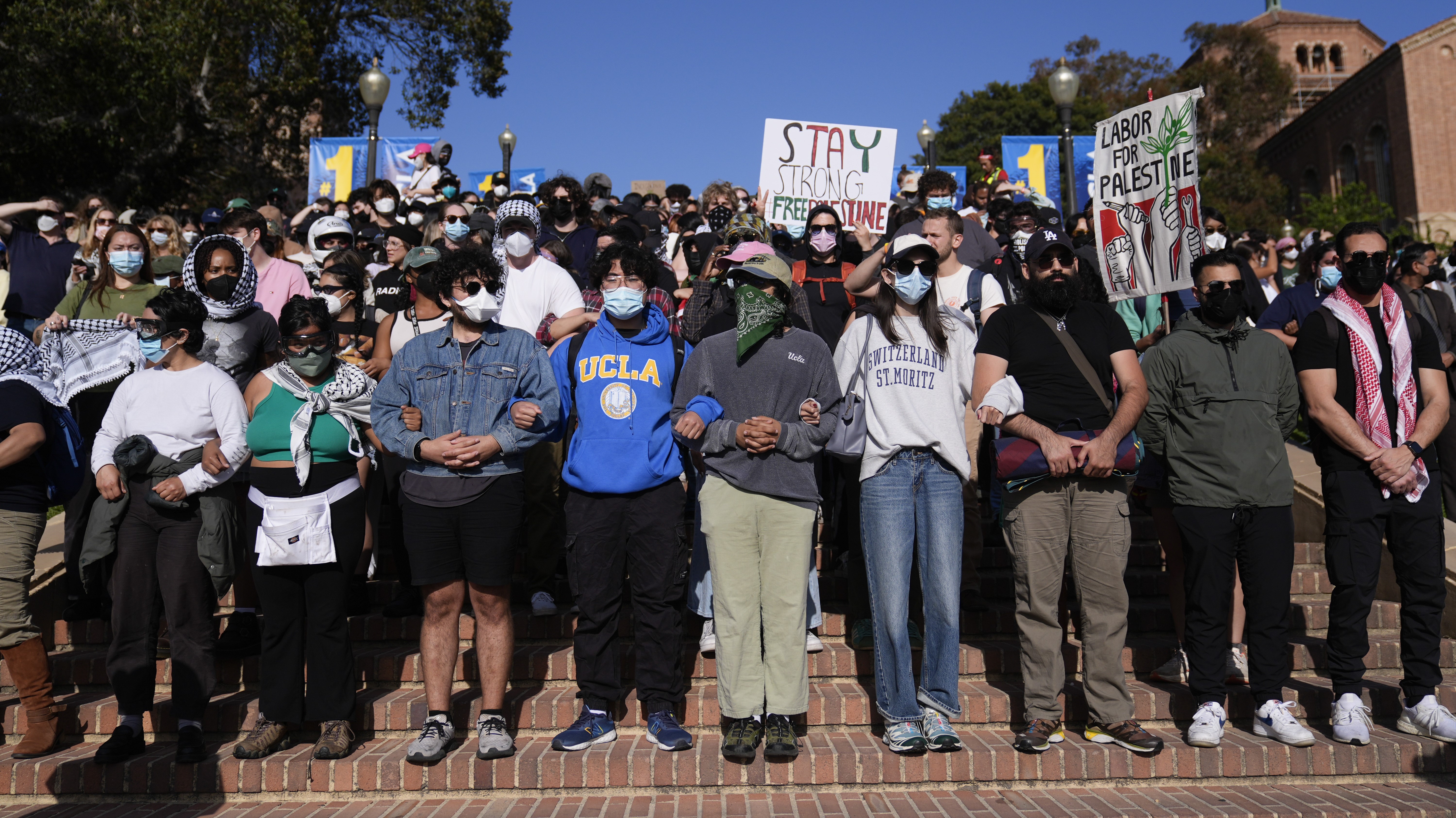 Demonstrators lock arms on the UCLA campus, after nighttime clashes between Pro-Israel and Pro-Palestinian groups, Wednesday, May 1, 2024, in Los Angeles. (AP Photo/Jae C. Hong)