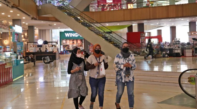 Women wearing face masks as a precaution against the coronavirus outbreak walk inside a shopping mall in Tangerang, Indonesia. (Photo / Tatan Syuflana, AP)