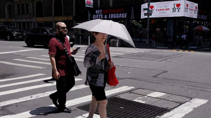 A woman protects herself from the heat in New York City on June 24, 2025. Dangerously high temperatures are forecast through midweek in Washington, Baltimore, Philadelphia, New York City and Boston. Photo / AFP