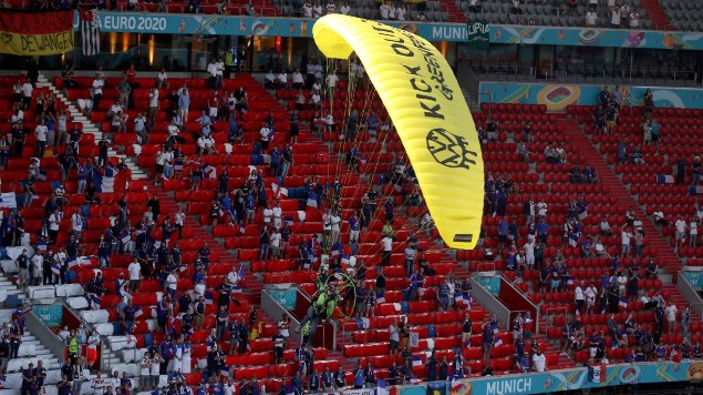 A Greenpeace paraglider lands in the stadium prior to the Euro 2020 soccer championship group F match between France and Germany. (Photo / AP)