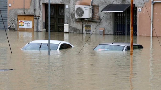 Cars are submerged in a flooded road, in Faenza, Italy. Photo / AP