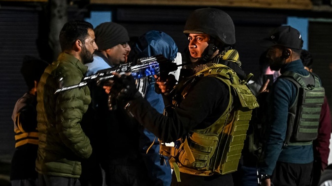 Indian Army personnel stand guard as they speak with tourists near Pahalgam, south of Srinagar, on April 22, 2025, after an attack. Photo / AFP
