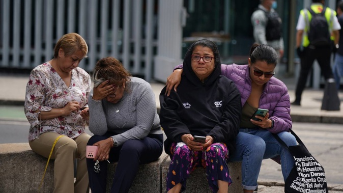 People gather outside after a magnitude 7.6 earthquake was felt in Mexico City. One person has been reported killed after a wall at a mall fell. Photo / AP