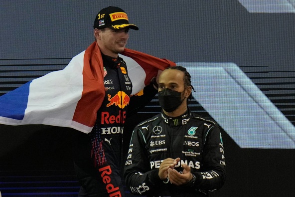Red Bull driver Max Verstappen of the Netherlands celebrates after he became the world champion, while Lewis Hamilton looks on. (Photo / AP)