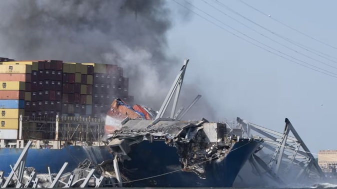 Explosive charges are detonated to bring down sections of the collapsed Francis Scott Key Bridge resting on the container ship Dali. Photo / AP