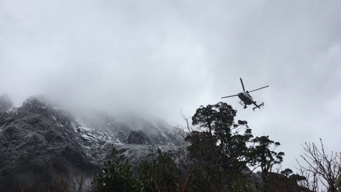 A helicopter hovers above the hut area during hunt for missing man. Photo / Supplied