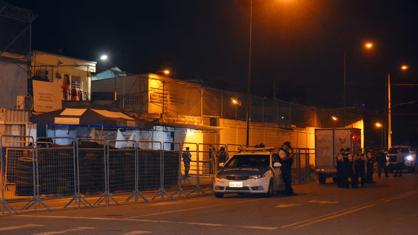 Police officers stand guard at the entrance of Machala prison in Ecuador after a deadly day at the facility. Photo / Luis Suarez, AFP