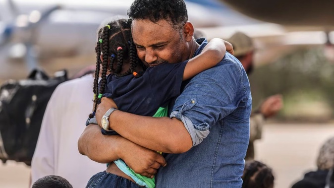 Violinist Othmano hugs his daughter before boarding an RAF C-130 at Wadi Seidna military airport, 2km north of Khartoum, Sudan. Photo / AP