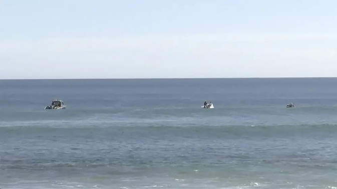 In this image from a video, searchers on boats conduct an operation in waters in Elliston, Australia Saturday, May 13, 2023. Police continued to search Monday for remains of a 46-year-old surfer who was attacked by a shark off the south Australian coast two days earlier. (Australian Broadcasting Corp. via AP)