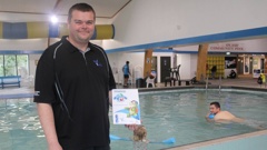 SplashSave founder Phil Waggott at Wai Splash with his manual, which guides parents in teaching their children water safety.