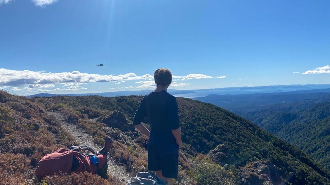 Tramper Rowan Hart watches the approach of the Greenlea Rescue Helicopter to pick up injured friend Fergus White. Photo / Edie Thiele