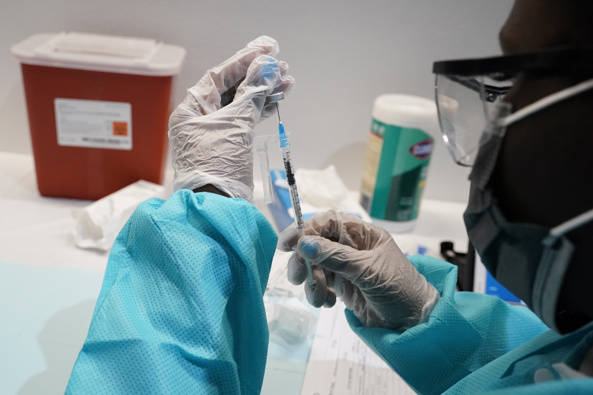 A health care worker fills a syringe with the Pfizer Covid-19 vaccine. (Photo / AP)