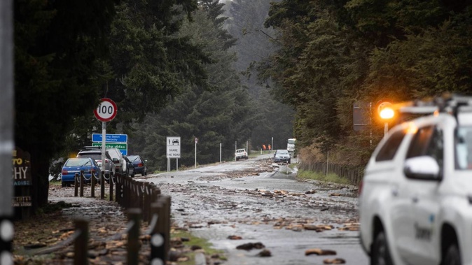 Debris covers the road to Glenorchy just outside Queenstown on Friday after the region's wettest 24-hour period in 24 years. Photo / George Heard