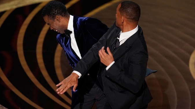 Will Smith hits presenter and actor Chris Rock on stage while presenting the award for best documentary feature at the Oscars. (Photo / AP)
