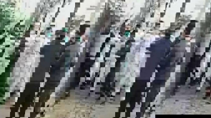 Security personnel in protective clothing attack a man during a protest at the world's biggest Apple iPhone factory in central China. Photo / AP