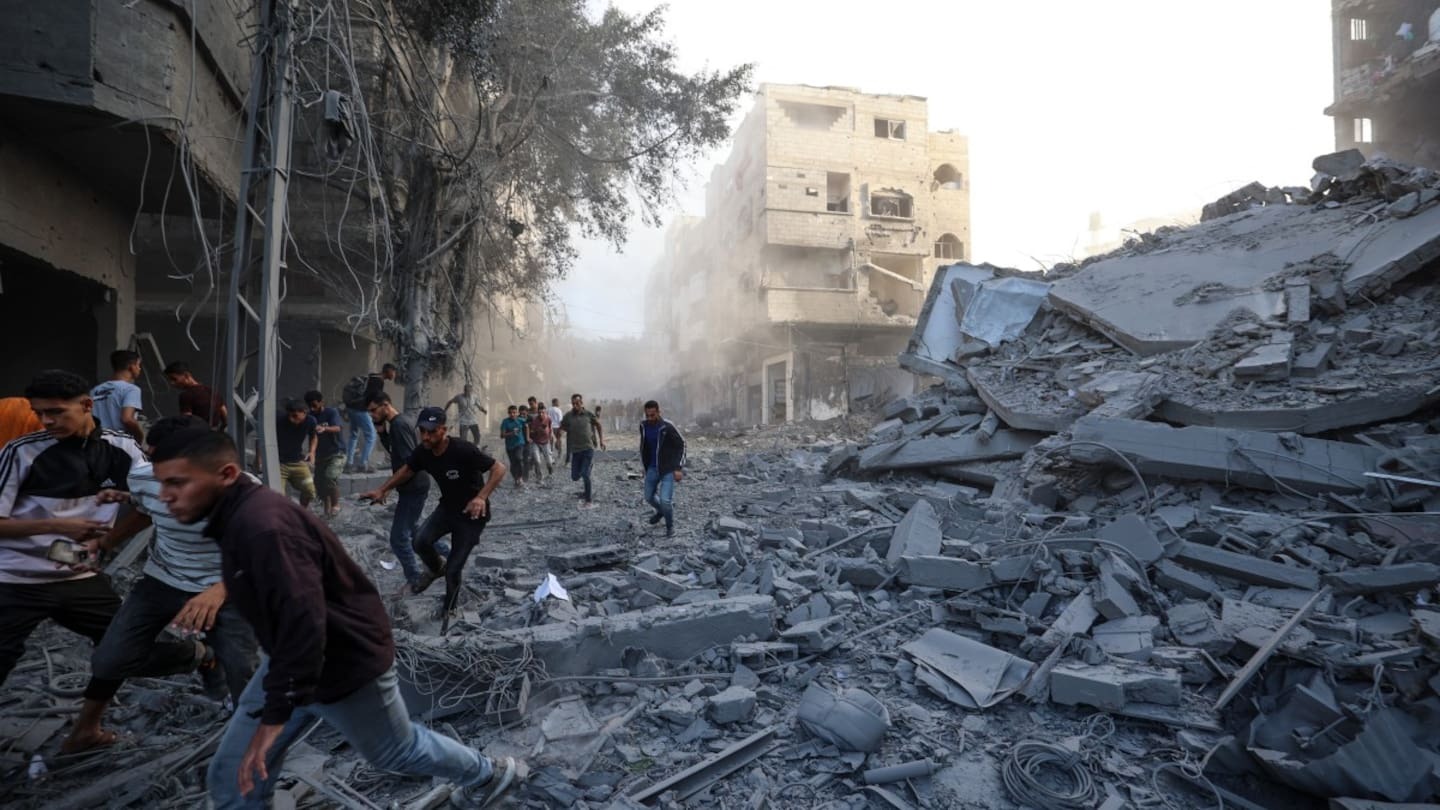 People run for cover after an Israeli strike targeted a building in the Bureij camp for Palestinian refugees in the central Gaza Strip. Photo / Eyad Baba, AFP
