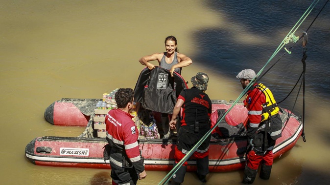 A Dartmoor resident hopping onto a boat to return to lower Dartmoor, across the Mangaone River, with supplies. Photo / Paul Taylor