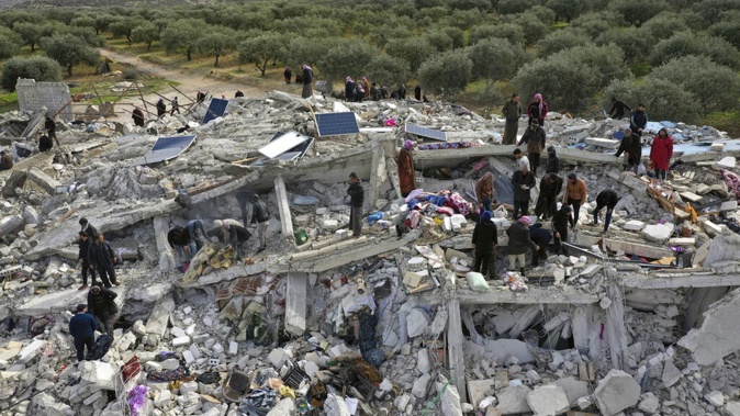 Civil defence workers and residents search through the rubble of collapsed buildings in the town of Harem near the Turkish border in the Idlib province, Syria. Photo / AP