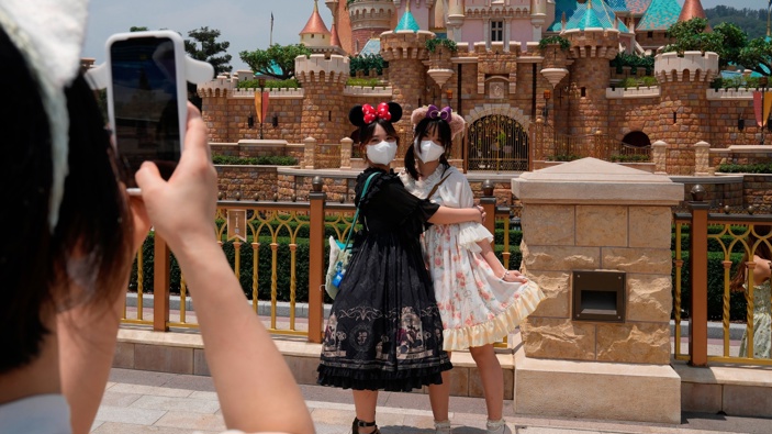 Visitors wearing face masks take photos at the Hong Kong Disneyland, Thursday, April 21, 2022. (Photo / AP)