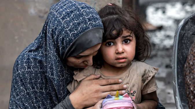 A Palestinian family sits near destroyed houses following a strike in Rafah on the southern Gaza Strip on November 6, 2023. Mohammed Abed/AFP/Getty Images