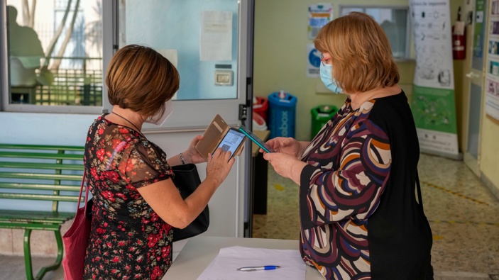 In this file photo, a teacher has her "Green Pass" checked by a school worker as she arrives at the "Isacco Newton" high school, in Rome. (Photo / AP)
