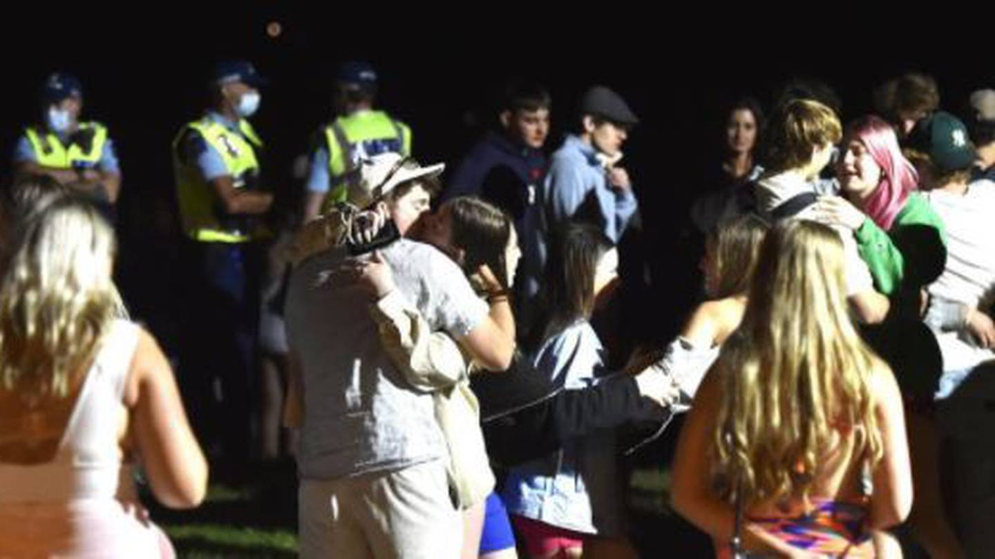 Watched by police, young people gather near the Wanaka waterfront in their thousands on New Year's Eve. Photo / Gregor Richardson