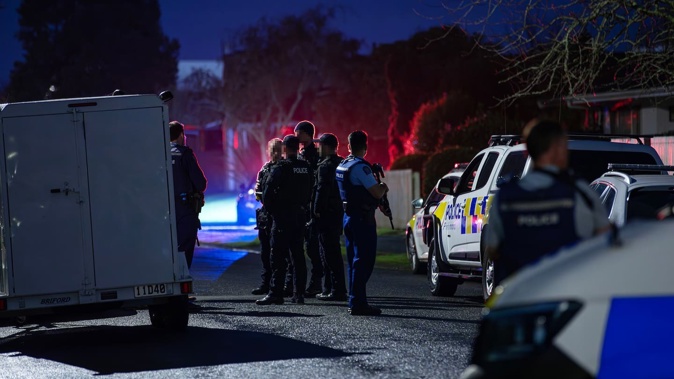 Armed police outside a Bellmont Ave property in Chartwell, Hamilton, last night after an alleged shooting. Photo / Hayden Woodward