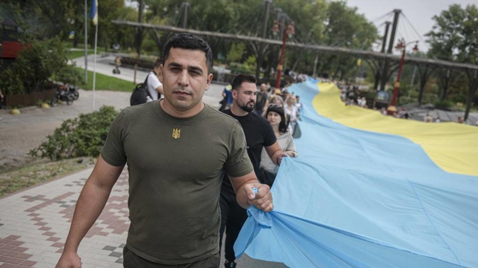 Activists hold a giant Ukrainian flag during an event "Ukraine united" in Kyiv. Photo / AP
