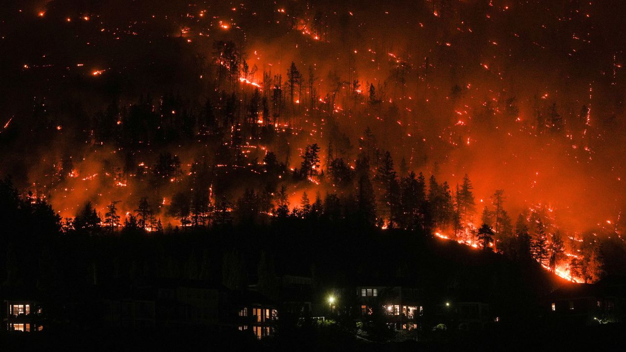 The McDougall Creek wildfire burns on the mountainside above houses in West Kelowna on Friday. Darryl Dyck/The Canadian Press/AP