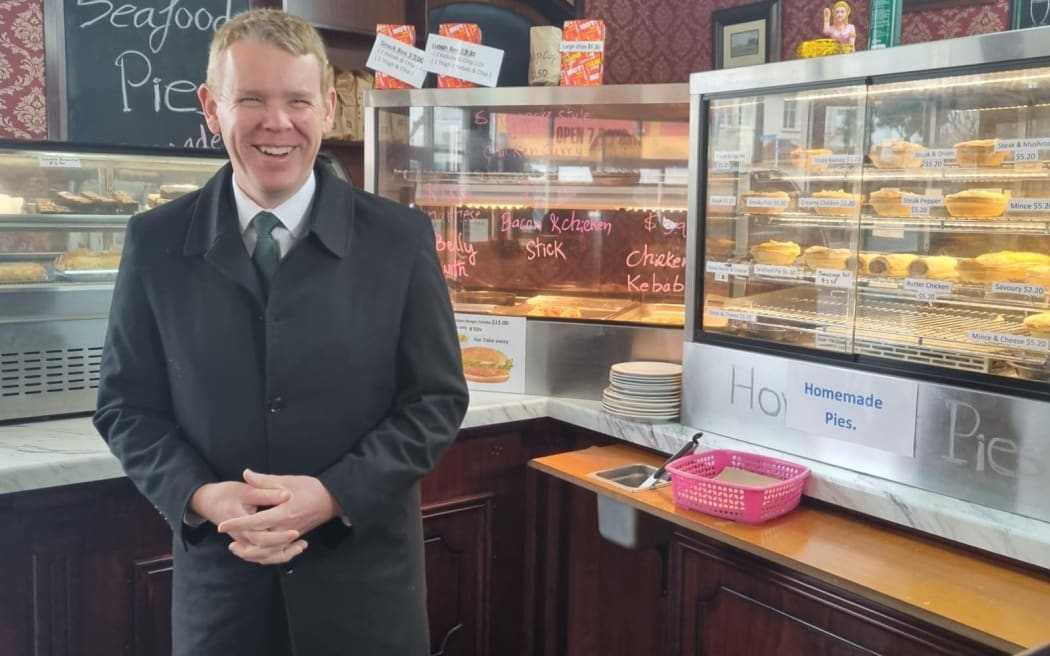 Chris Hipkins poses next to sausage rolls.