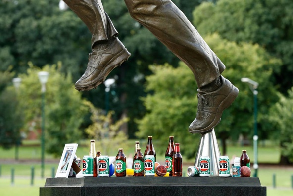 Beer cans are left as tributes at the base of the Shane Warne statue outside the Melbourne Cricket Ground. (Photo / Getty)