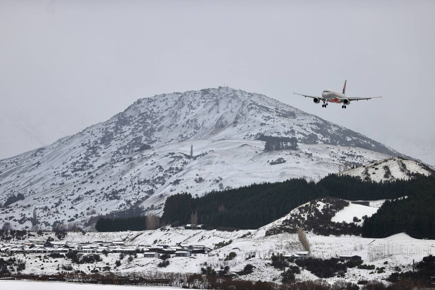 A plane comes in to land at a snow-covered Queenstown airport. (Photo / George Heard)