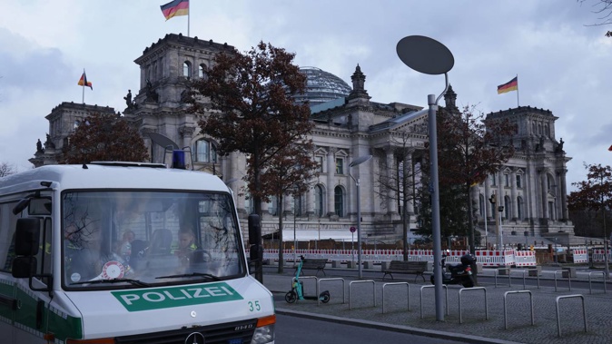 A police van stands outside the Reichstag, seat of the Bundestag, Germany's parliament, on the day police conducted nationwide raids against a suspected insurrectionist group. Photo / Getty Images