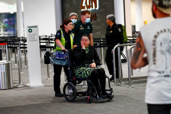 An Air New Zealand employee is wheeled to a waiting ambulance at Queenstown Airport last night. Photo / James Allan