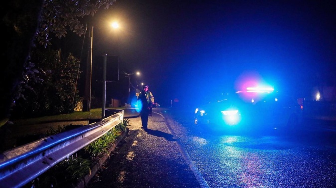 A police officer at the scene where a man was shot and killed during a stand-off with police last night. (Photo / Mike Scott)