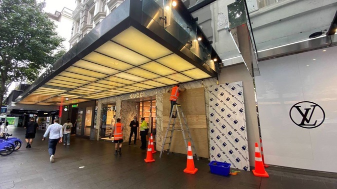 Workers replacing the glass in front of the Gucci store in Queen St. Photo / Craig Kapitan