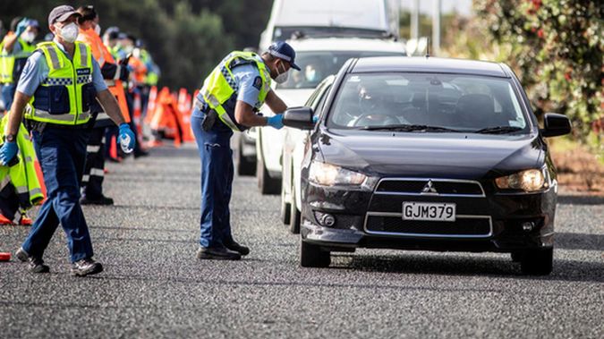 Police and iwi volunteers check for vaccination passes or negative Covid-19 tests at a State Highway 1 checkpoint at Uretiti, Northland, on 15 December 2021. Photo / Michael Craig