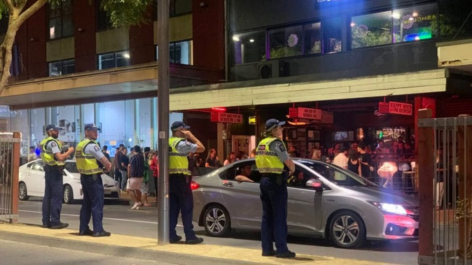 Police line up outside a Courtenay Pl bar in Wellington. Photo / Jemima Huston, RNZ