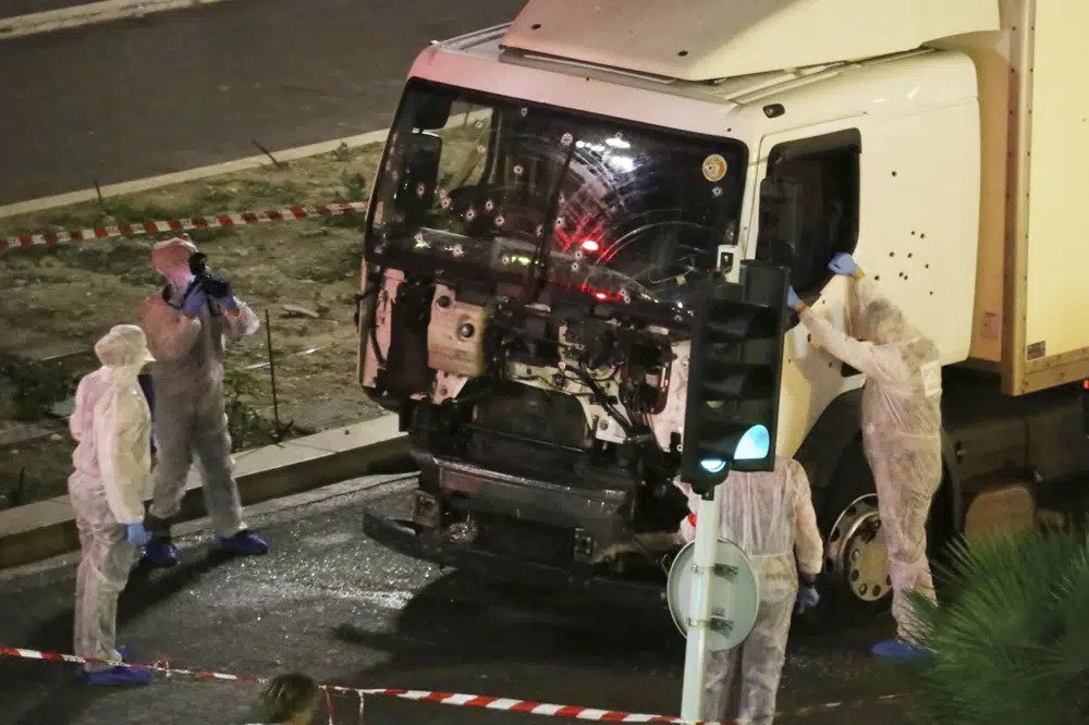  Authorities investigate a truck after it plowed through Bastille Day revelers in the French resort city of Nice, France, killing 86 people on July 14, 2016. A French court on Tuesday Dec.13, 2022 convicted eight people charged in connection with a truck attack more than six years ago by an Islamic State sympathizer that killed 86 people celebrating Bastille Day in the French Riviera city of Nice. (Sasha Goldsmith via AP, File)